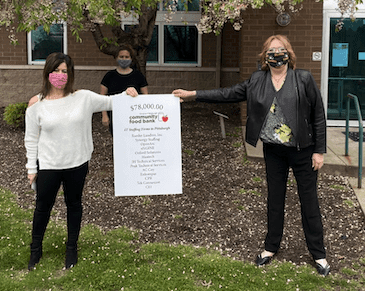 Three people holding sign for FoodBank donations